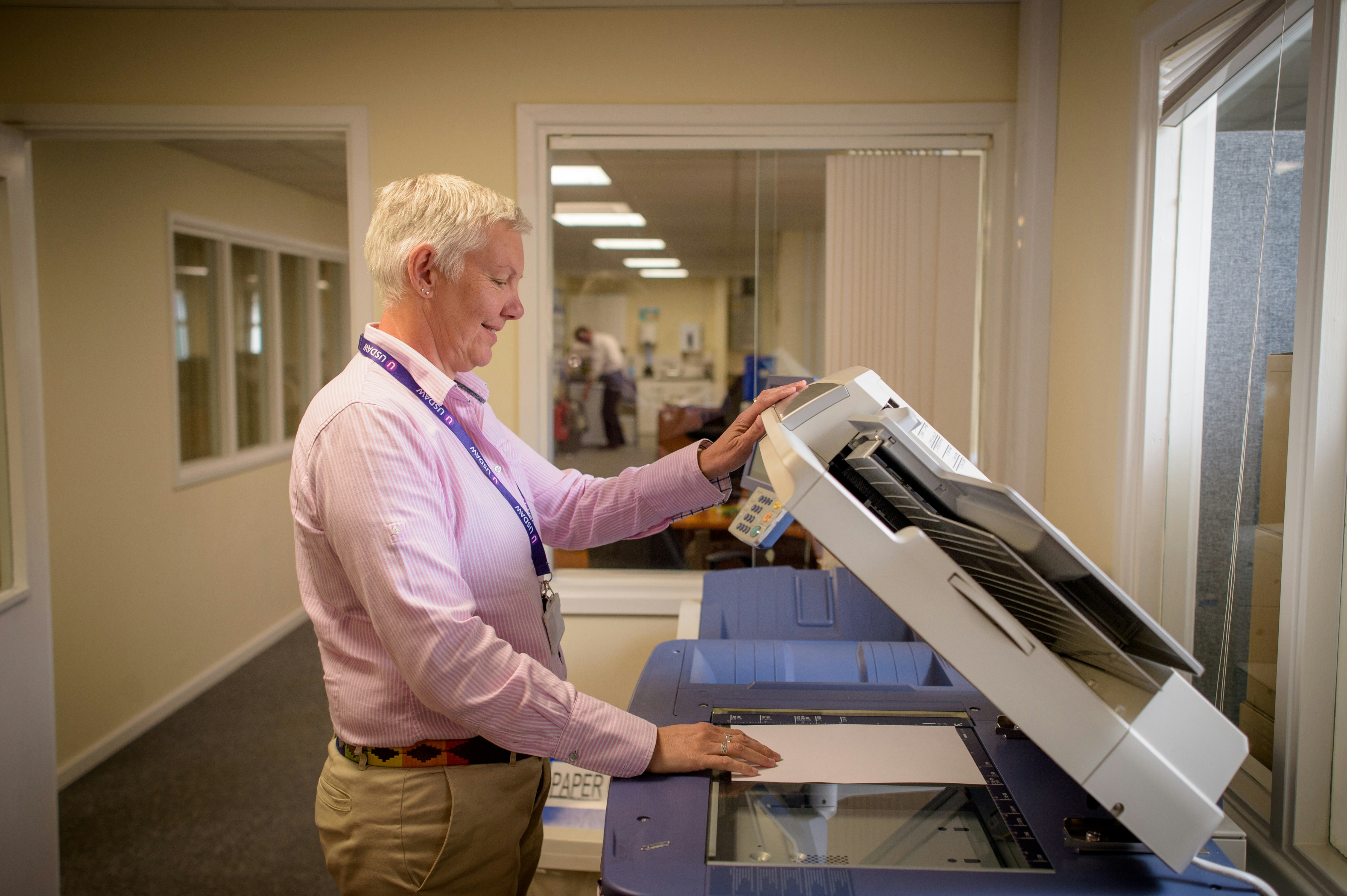 Volunteer manager scanning volunteer expense receipts in an office as part of a manual reimbursement process